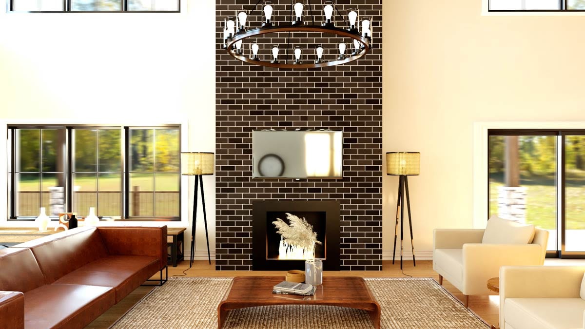 Great room with two-story vaulted ceiling, large windows, dark brick fireplace, and modern chandelier.