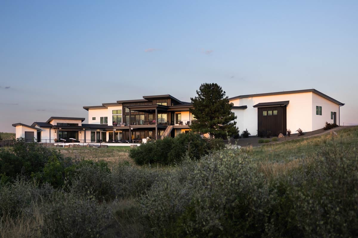 Modern house plan exterior with multiple levels, flat rooflines, large windows, and a two-car garage.