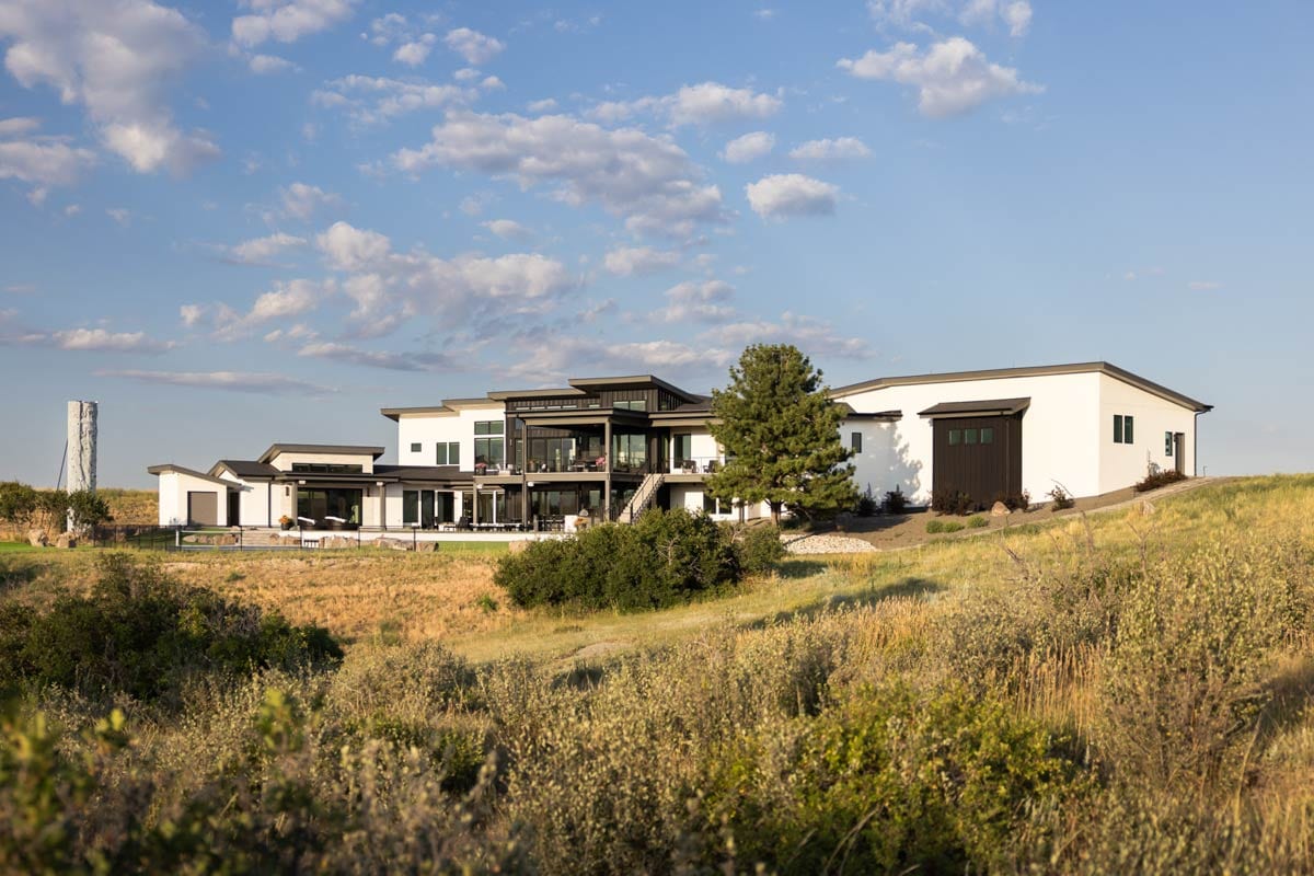 Modern house plan exterior with flat rooflines, multiple gables, large windows, and an attached garage.